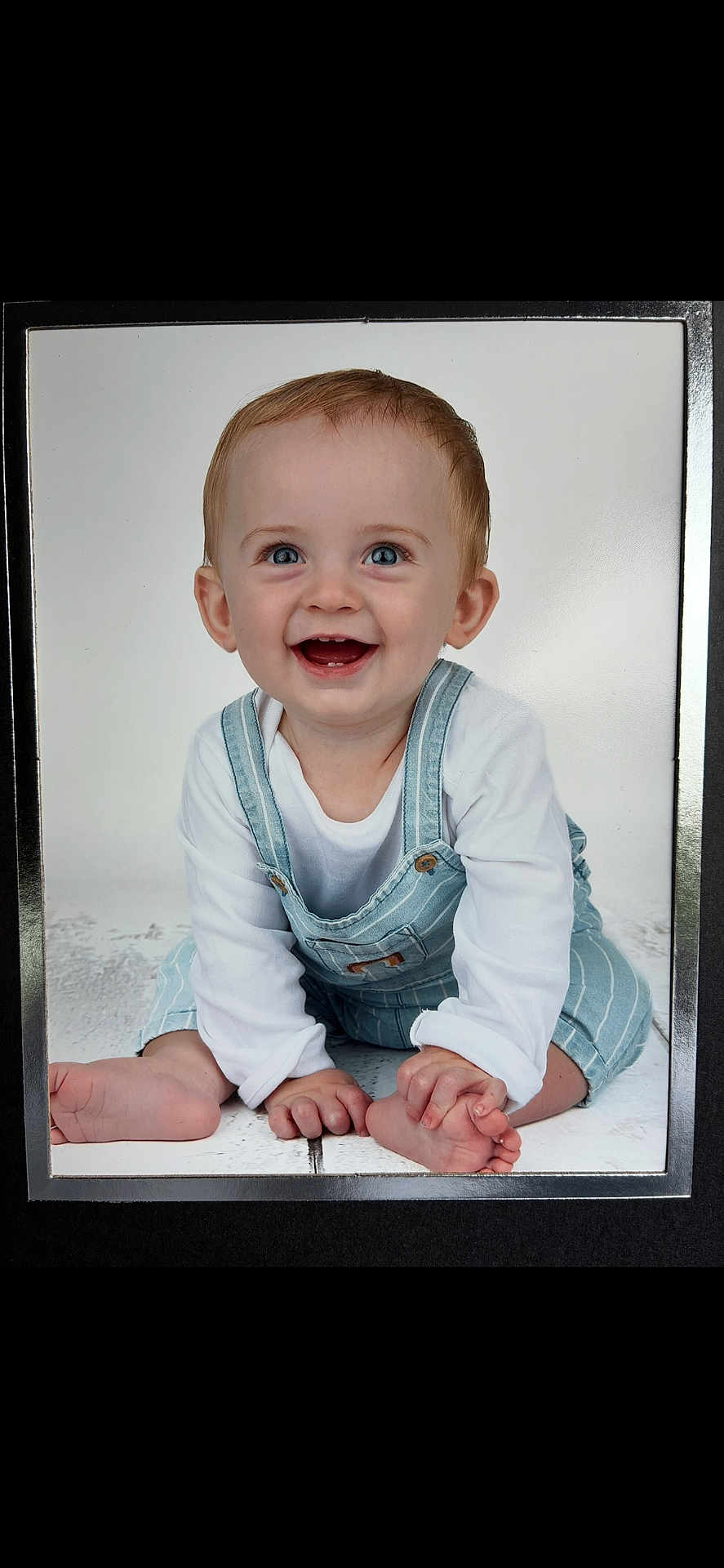 Isaac joined the competition — help win amazing prizes! baby, child, smiling, happy, blue_eyes, overalls, white_shirt, sitting, floor, toes, hands, portrait, cute, infant, crawling_pose, studio_photo, bright, clean_background, young, playful