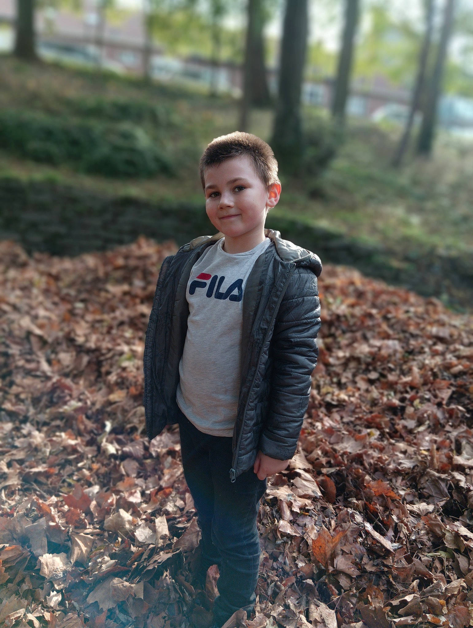 Logan a rejoint le concours — aidez-le/la à gagner de superbes lots ! botany, branch, deciduous, flash_photography, forest, grass, happy, jacket, jeans, joy, landscape, natural_environment, people_in_nature, person, plant, smile, toddler, tree, trousers, wood
