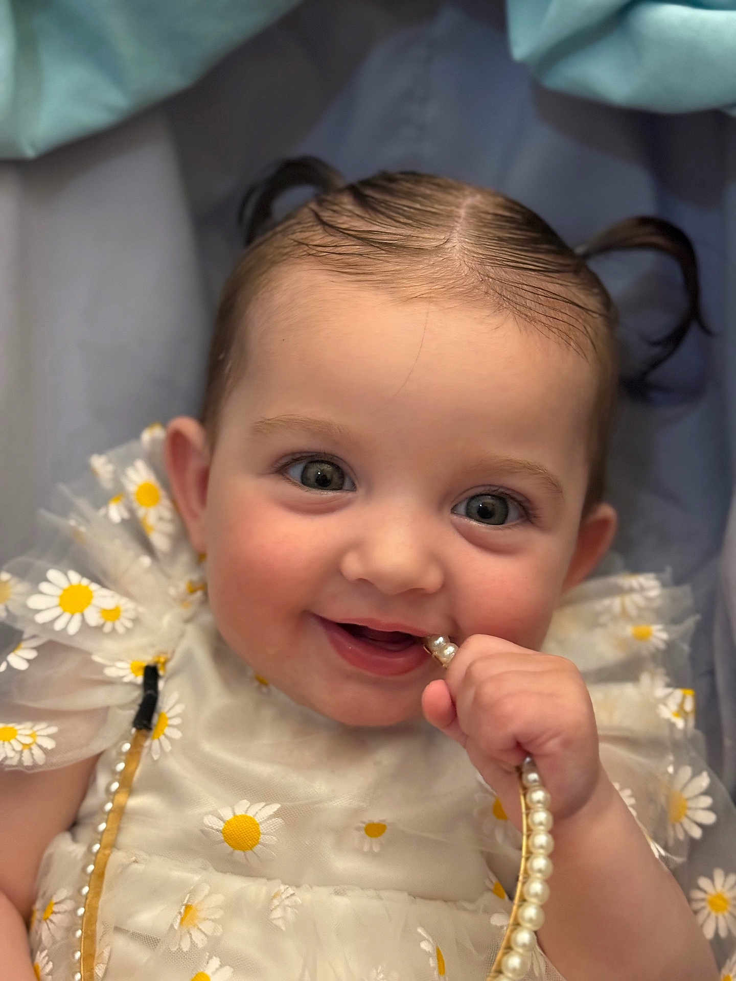 Nazhia a rejoint le concours — aidez-le/la à gagner de superbes lots ! adorable, baby, child, closeup, cute, daisy_pattern, dress, fabric, face, hand, happy, infant, pearl_necklace, person, pigtails, playful, portrait, smile, soft_lighting, young