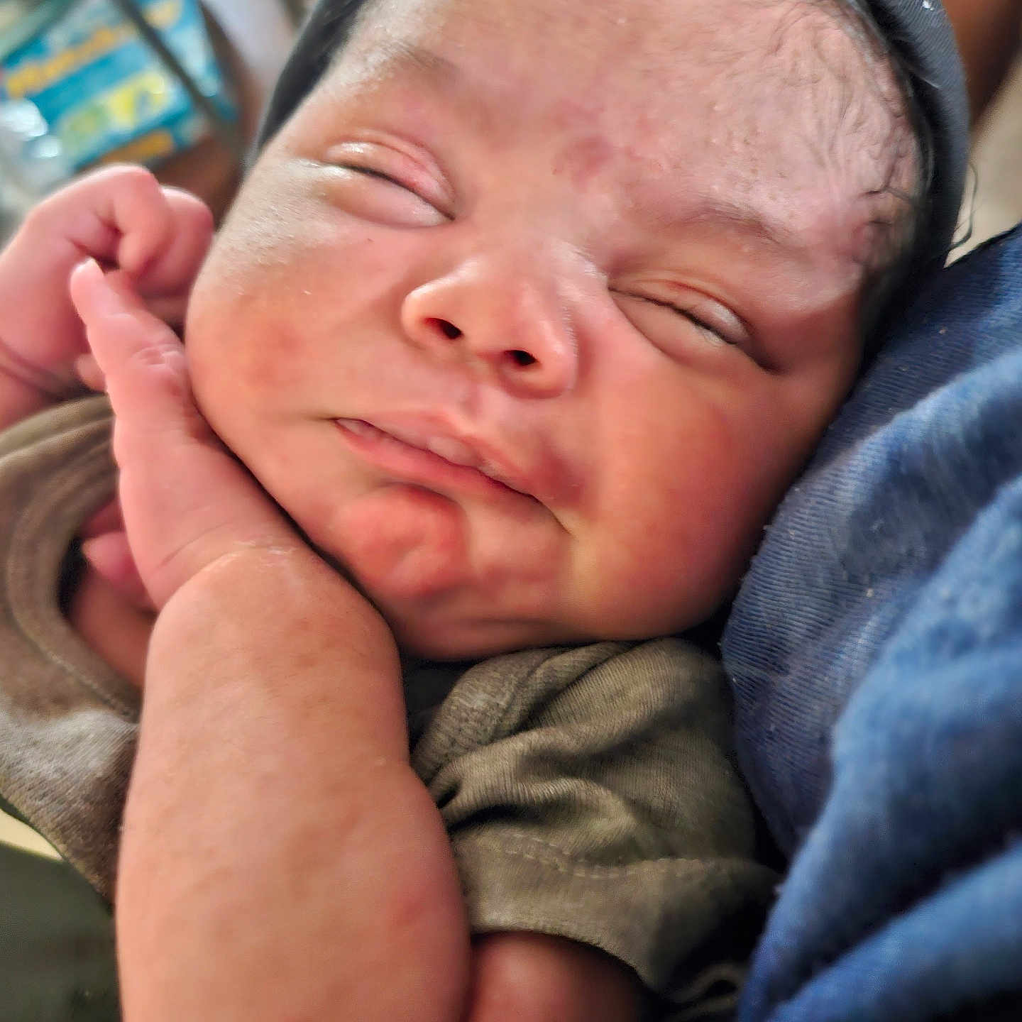 Javion is registered to the contest to win money with this photo: baby, blanket, bodypart, cap, clothing, face, finger, frown, hand, hat, head, hoodie, knitwear, newborn, person, photography, portrait, sad, sleeping, sweater