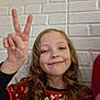 casual, celebration, child, curly_hair, cute, fashion, friendly, fun, girl, hand_gesture, happy, indoor, peace_sign, pearl_necklace, person, portrait, red_sequin_top, smile, white_brick_wall, young