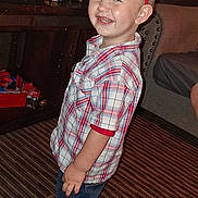 Bryson is registered to the contest to win money with this photo: barefoot, boy, carpet, celebration, child, crown, cute, furniture, happy, headwear, indoor, person, plaid_shirt, room, shorts, smiling, standing, television, toddler, toys