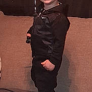 Bryson is registered to the contest to win money with this photo: casual, child, clothing, couch, curtains, face, furniture, hair, happy, home, hoodie, indoor, light, pants, person, portrait, smiling, standing, toddler, young