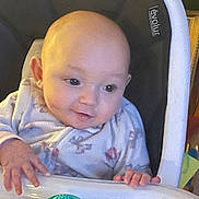 Blakeleigh is registered to the contest to win money with this photo: baby, child, high_chair, onesie, toy, infant, face, hands, smile, indoor, person, seat, play, cute, expression, young, looking, colorful, plastic, furniture