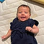 Mila joined the competition — help win amazing prizes! baby, infant, smiling, lying_down, blue_clothing, mattress, textured_surface, cute, child, playful, young, face, small_hands, happy, indoors, fabric, soft_lighting, person, toddler, casual
