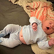 Emilio is registered to the contest to win money with this photo: baby, infant, sleepy, yawning, striped_pajamas, animal_slippers, blanket, bed, soft, cozy, cute, newborn, person, indoor, rest, lying_down, child, comfortable, warm, toddler