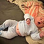 baby, infant, sleepy, yawning, striped_pajamas, animal_slippers, blanket, bed, soft, cozy, cute, newborn, person, indoor, rest, lying_down, child, comfortable, warm, toddler