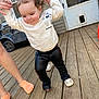 Hazel Hamby joined the competition — help win amazing prizes! toddler, child, person, walking, helping_hands, white_sweatshirt, minnie_mouse, black_pants, wooden_deck, door, pet_door, toy_car, outdoor, focused_expression, feet, orange_socks, casual_clothing, young_child, playtime, learning_to_walk
