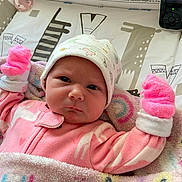 Lilly is registered to the contest to win money with this photo: baby, infant, pink_pajamas, mittens, blanket, hat, face, person, baby_monitor, indoor, cute, sleeping_area, newborn, expression, portrait, soft_texture, warm_clothing, child, cozy, resting