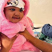 Skylar is registered to the contest to win money with this photo: baby, child, pink_clothing, fluffy_outfit, headband, minnie_mouse, smiling, hands, indoor, person, cute, happy, infant, portrait, warm_clothing, closeup, face, baby_girl, soft_texture, cozy