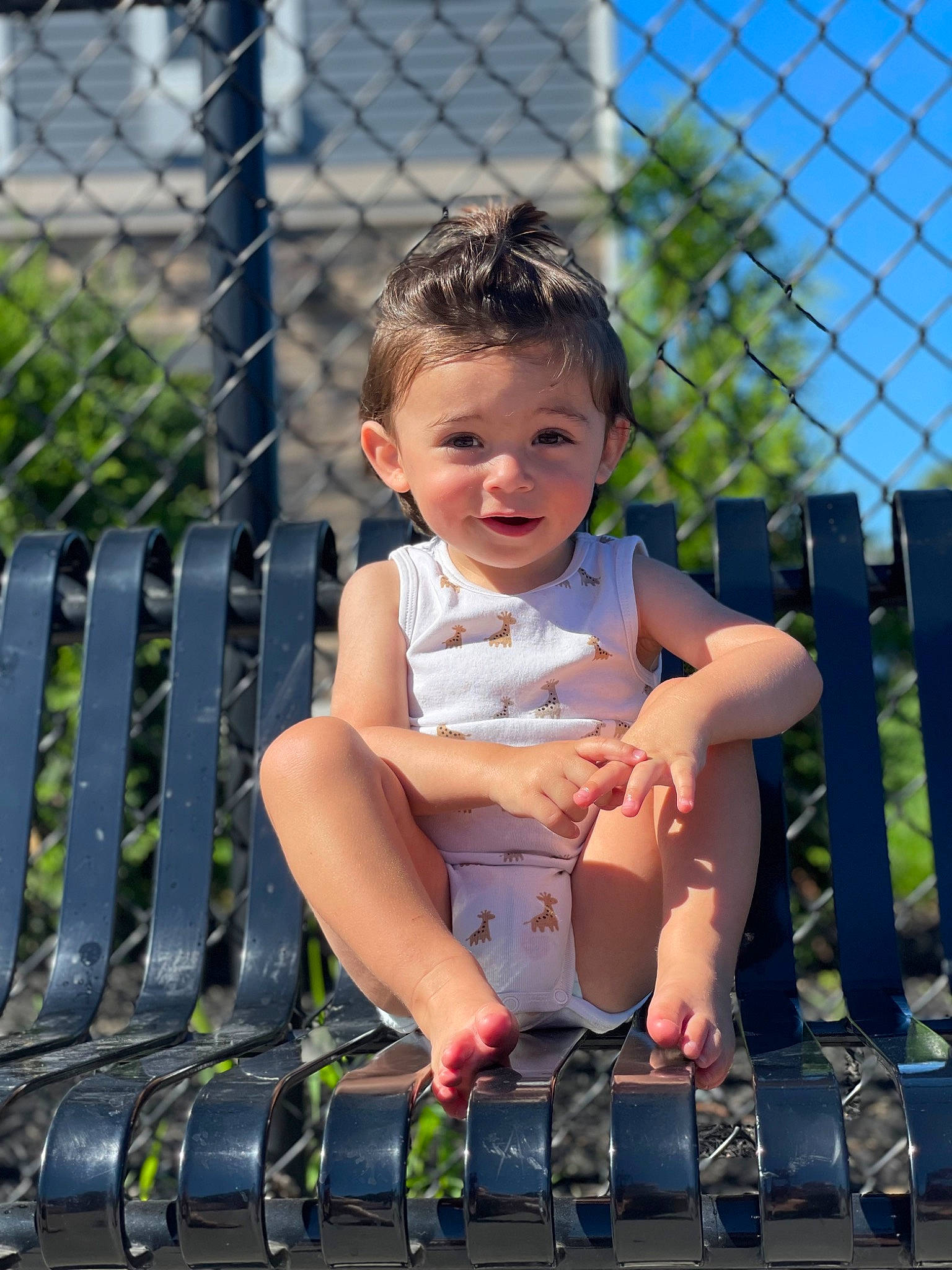 Colton is registered to the contest to win money with this photo: baby_toddler_clothing, child, fence, finger, fun, grass, happy, human_leg, leg, leisure, mesh, person, recreation, sandal, shorts, sky, smile, summer, thigh, toddler