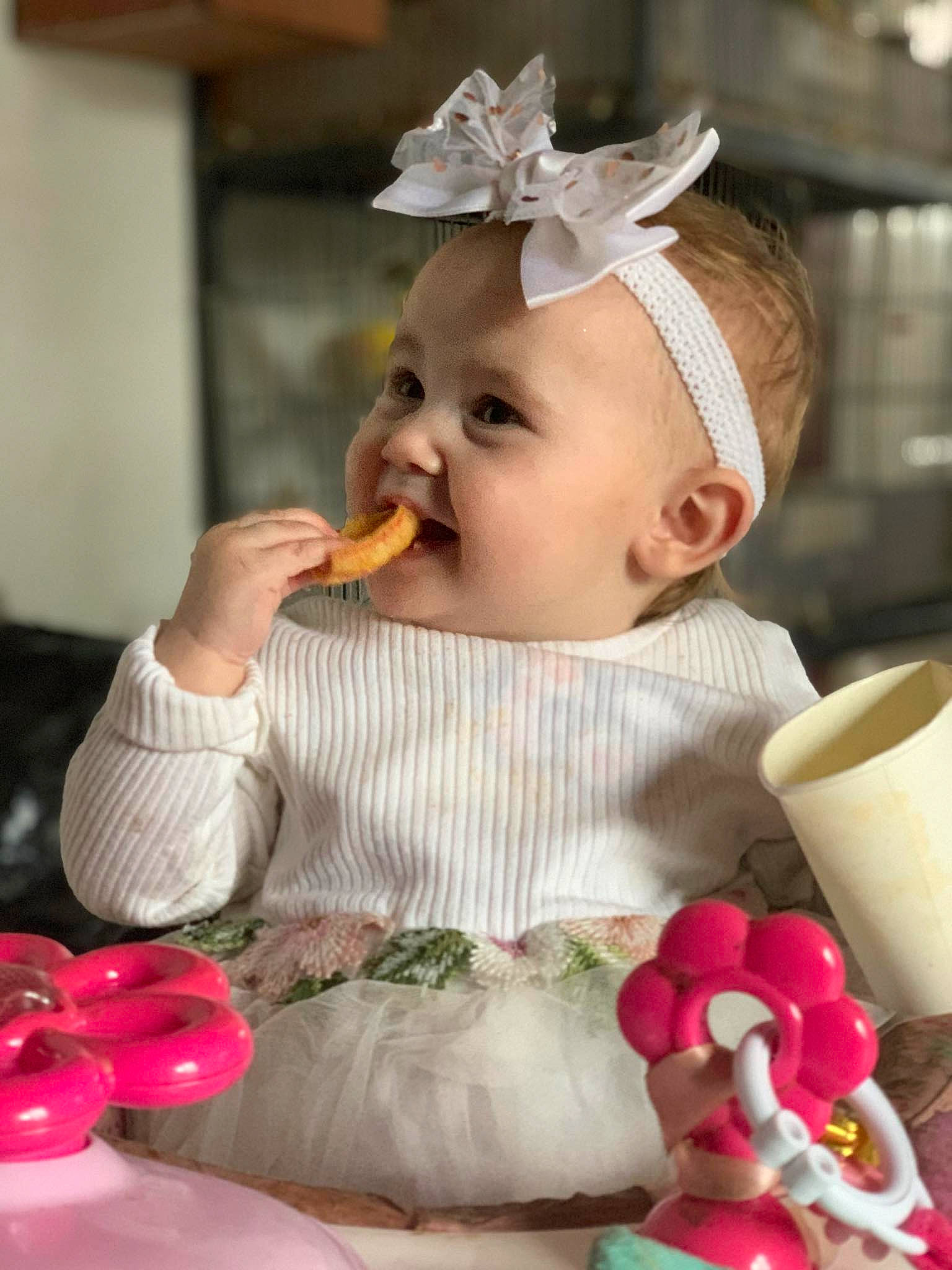 Romane participe au concours pour gagner de l'argent avec cette photo : baby, baby_toddler_clothing, child, cup, dress, drinkware, event, happy, hat, head, headpiece, person, petal, pink, serveware, sitting, skin, sweetness, tableware, toddler