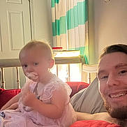 Lakelynn joined the competition — help win amazing prizes! baby, pacifier, man, beard, smile, bed, blanket, red_blanket, curtains, striped_curtains, door, indoor, child, person, furniture, light, home, cozy, portrait, candid