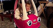 Lakelynn joined the competition — help win amazing prizes! child, toy_car, pink, indoor, living_room, car, playtime, smile, fun, kid, furniture, carpet, curtains, table, television, cushion, socks, happy, person, play