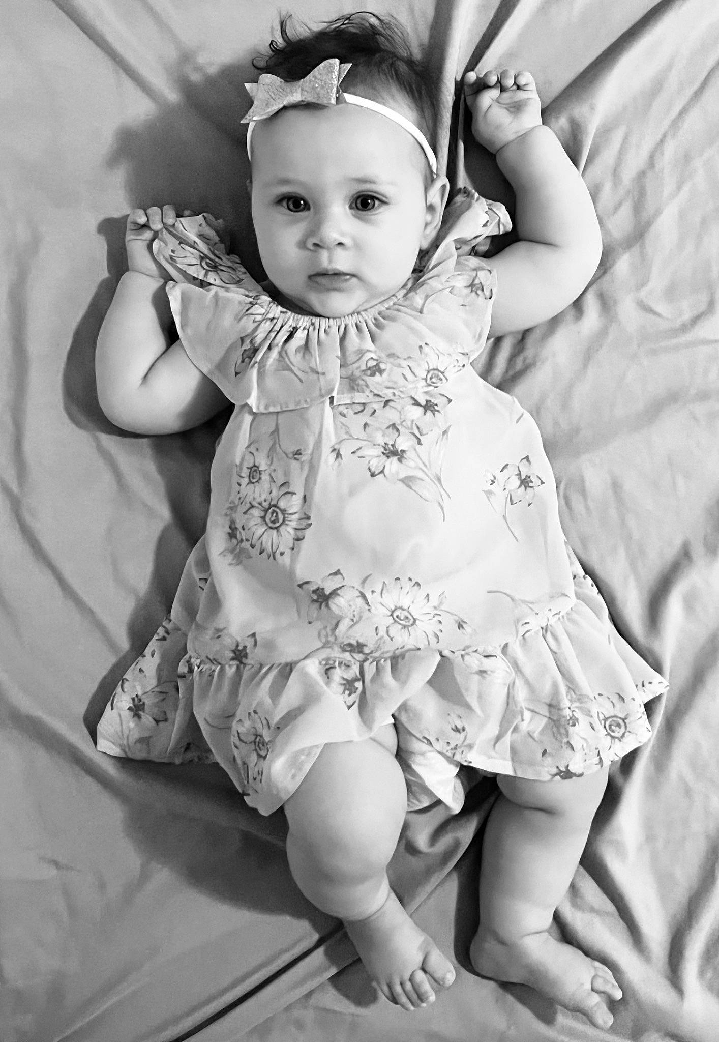 Scarlett is registered to the contest to win money with this photo: baby, baby_toddler_clothing, black_and_white, day_dress, dress, eye, eyelash, face, flash_photography, gesture, happy, head, iris, organ, person, photograph, pink, skin, standing, style