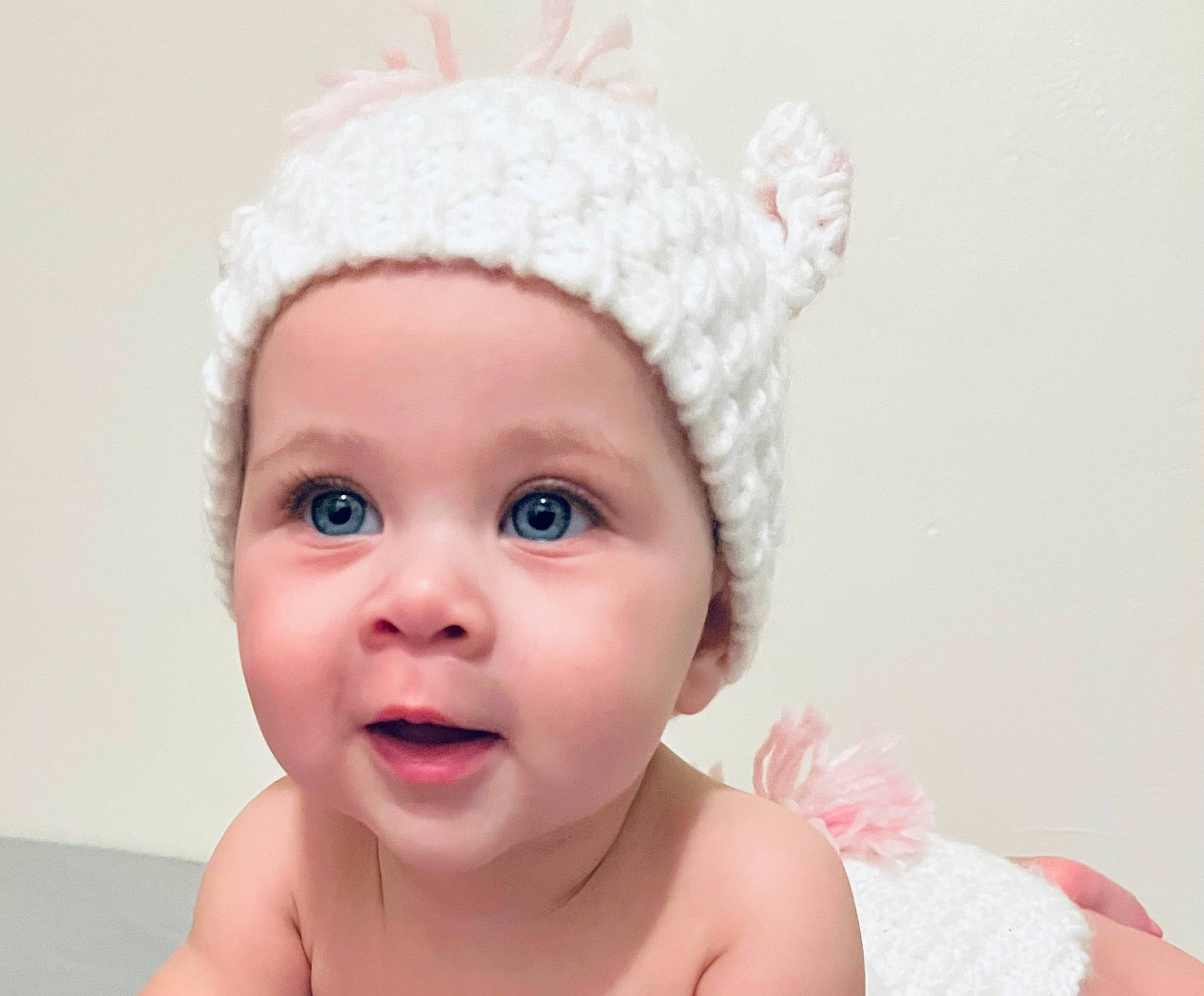 Scarlett is registered to the contest to win money with this photo: baby, cap, cheek, chin, ear, eye, eyebrow, eyelash, face, finger, gesture, happy, headpiece, headwear, lip, nose, person, pink, skin, smile