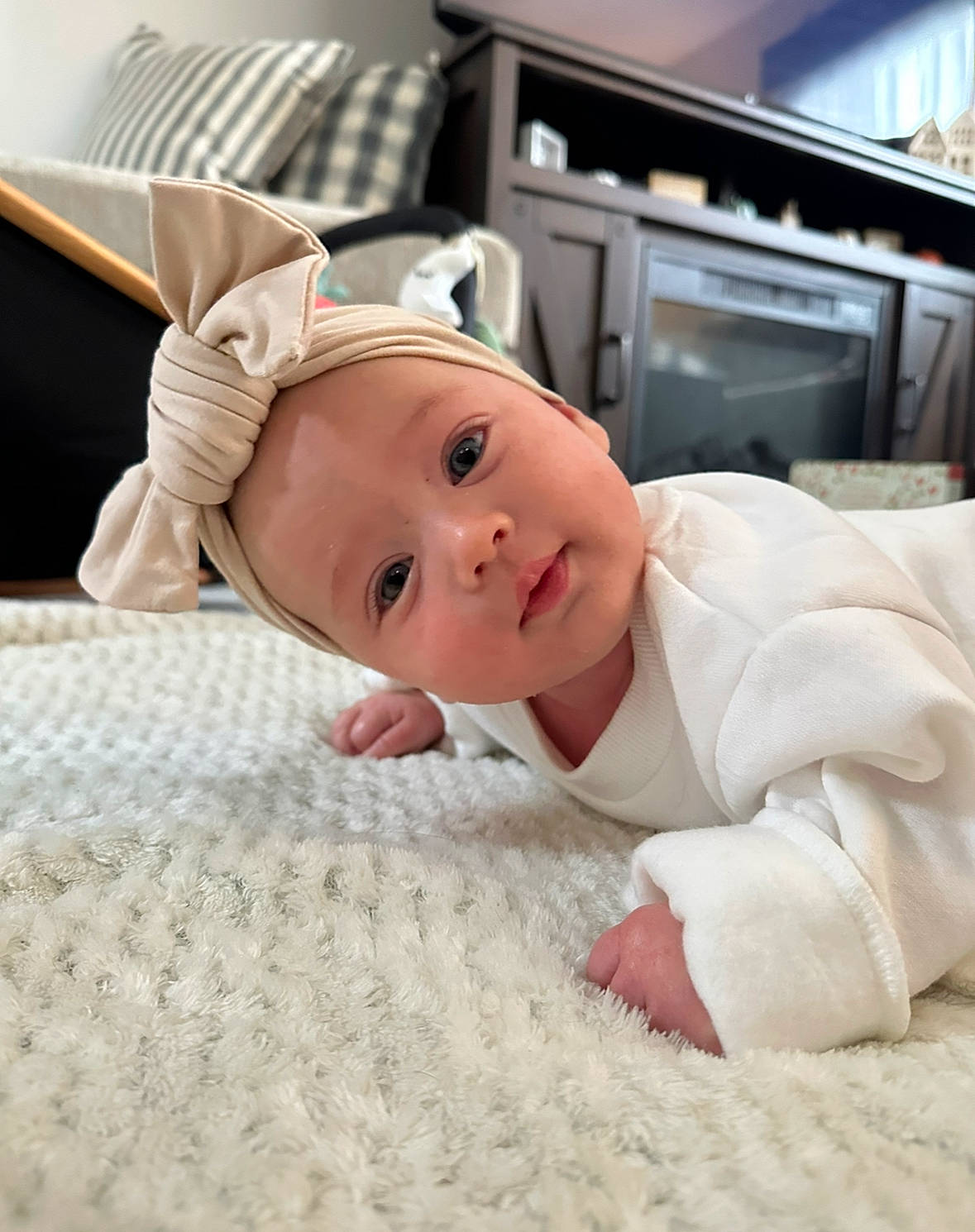 Lainey is registered to the contest to win money with this photo: baby, baby_safety, baby_sleeping, baby_toddler_clothing, bedding, child, comfort, flooring, home_appliance, kitchen_appliance, linens, machine, person, room, sitting, sleeve, smile, toddler, wood