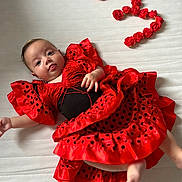Rosalia a rejoint le concours — aidez-le/la à gagner de superbes lots ! baby, celebration, child, clothing, colorful, cute, dress, fabric, flamenco_style, happy, infant, lying_down, number_three, person, polka_dot, portrait, red_dress, roses, tongue_out, white_background
