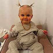 Lysia a rejoint le concours — aidez-le/la à gagner de superbes lots ! baby, child, pigtails, smile, socks, beige_clothing, changing_mat, indoor, cute, portrait, sitting, person, toddler, necklace, happy, infant, cozy, soft_lighting, baby_girl, playful