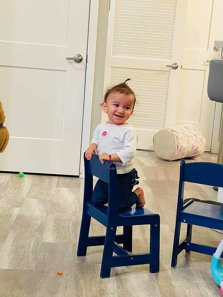 Emma joined the competition — help win amazing prizes! baby_toddler_clothing, chair, child, comfort, door, electric_blue, eye, floor, flooring, furniture, happy, hardwood, joy, knee, leisure, person, room, sitting, smile, toddler