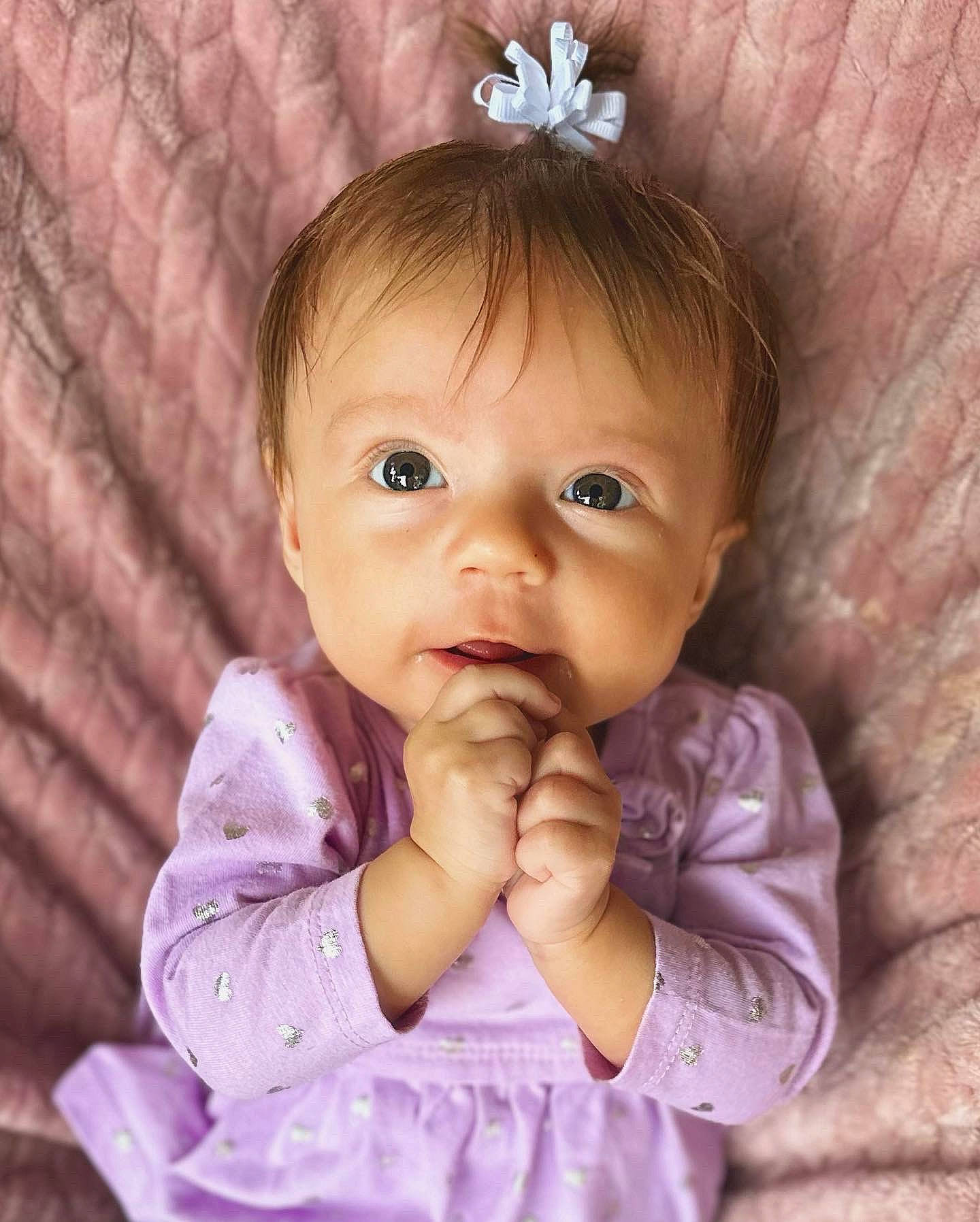 Fallon is registered to the contest to win money with this photo: baby, baby_toddler_clothing, cheek, ear, eye, eyebrow, eyelash, facial_expression, finger, gesture, happy, iris, lip, mouth, nose, organ, person, pink, purple, skin