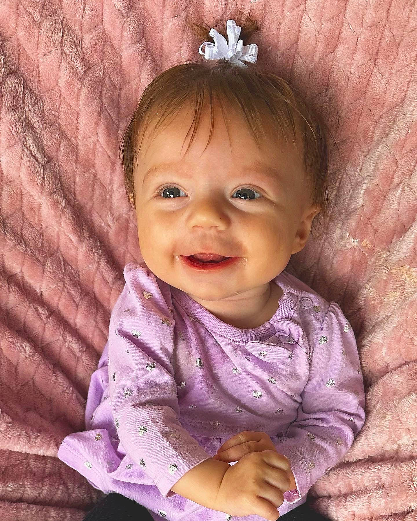 Fallon is registered to the contest to win money with this photo: baby_toddler_clothing, cheek, clothing, eye, facial_expression, finger, hand, happy, head, iris, lip, nose, organ, person, pink, product, purple, skin, sleeve, smile