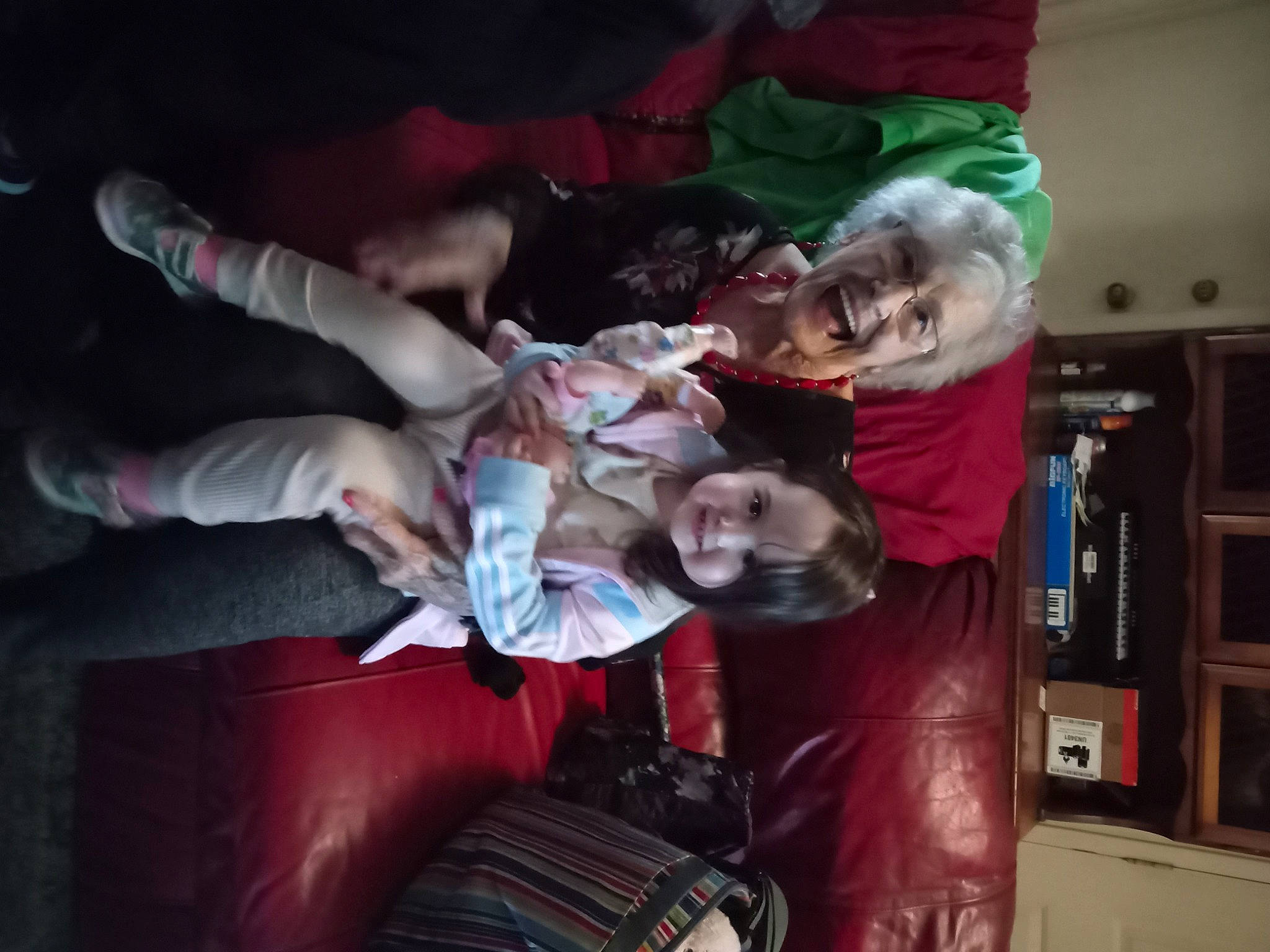 Katherine is registered to the contest to win money with this photo: bookcase, comfort, event, flesh, fun, fur, happy, joy, lap, laugh, magenta, person, room, shelf, shelving, sitting, smile, tree