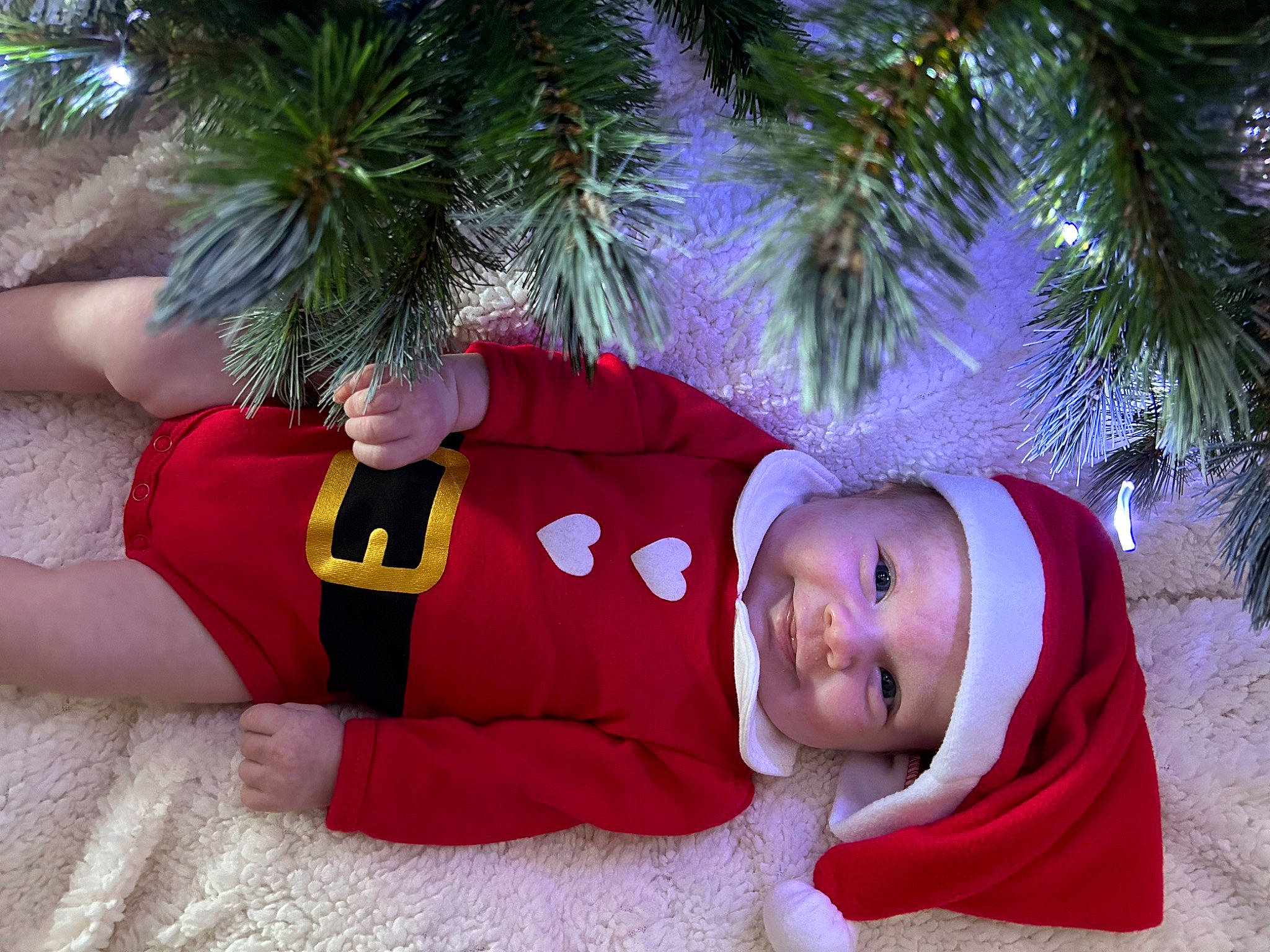 Aria participe au concours pour gagner de l'argent avec cette photo : baby_toddler_clothing, child, christmas, christmas_decoration, christmas_eve, christmas_ornament, christmas_tree, conifer, costume_hat, event, fun, happy, hat, headwear, holiday, human_leg, leisure, person, smile, thigh