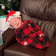 Grayson is registered to the contest to win money with this photo: baby, sleeping, plaid_pajamas, santa_hat, christmas_tree, ornaments, brown_leather_chair, holiday, festive, cozy, infant, indoor, holiday_decor, peaceful, child, cute, relaxing, seasonal, celebration, home