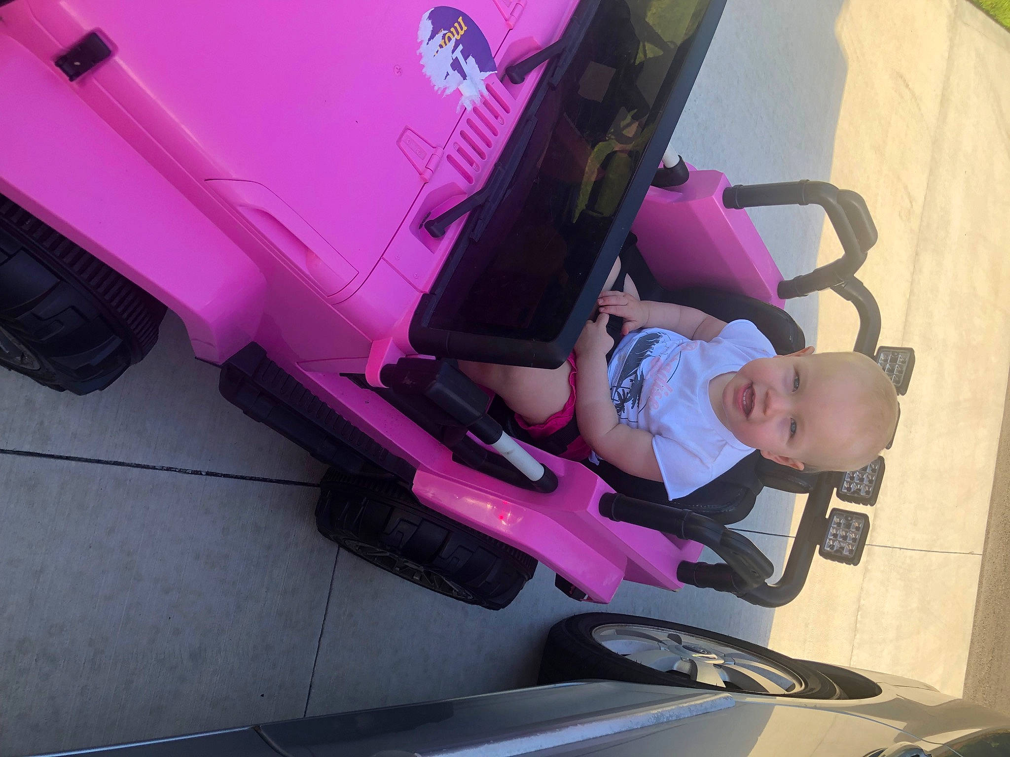 Laurel is registered to the contest to win money with this photo: arm, auto_part, automotive_design, automotive_exterior, automotive_tire, bumper, fender, hand, human_body, leg, magenta, motor_vehicle, person, pink, purple, shoe, sneakers, thigh, tire, vehicle_door