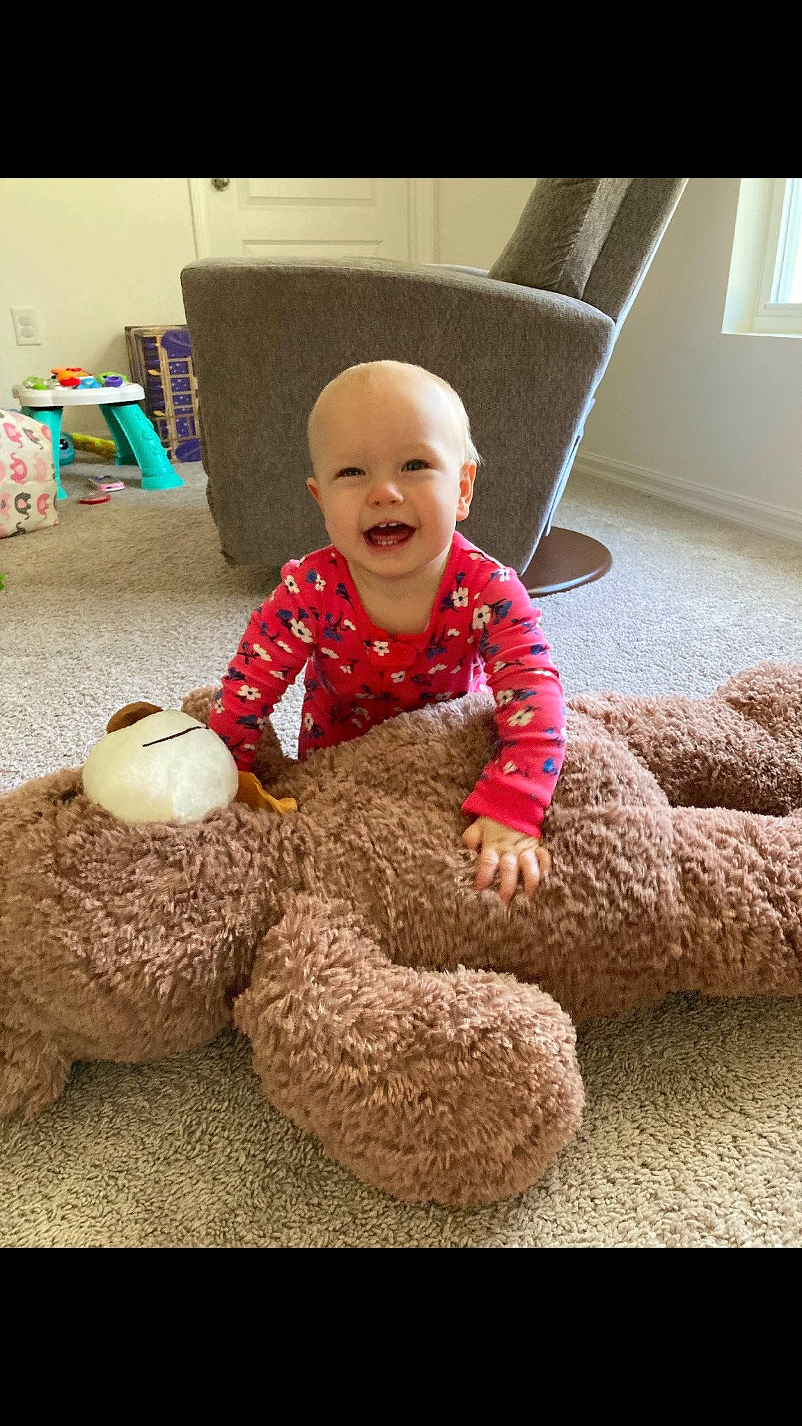 Laurel is registered to the contest to win money with this photo: baby, baby_toddler_clothing, child, comfort, floor, flooring, fun, happy, person, play, pumpkin, room, sitting, sleeve, smile, stuffed_toy, t_shirt, teddy_bear, toddler, toy