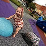 Sequoia is registered to the contest to win money with this photo: baby, child, playground, smiling, waving, romper, blue, purple, slide, backpack, outdoor, urban, park, happy, footwearless, toy, tree, building, daytime, person