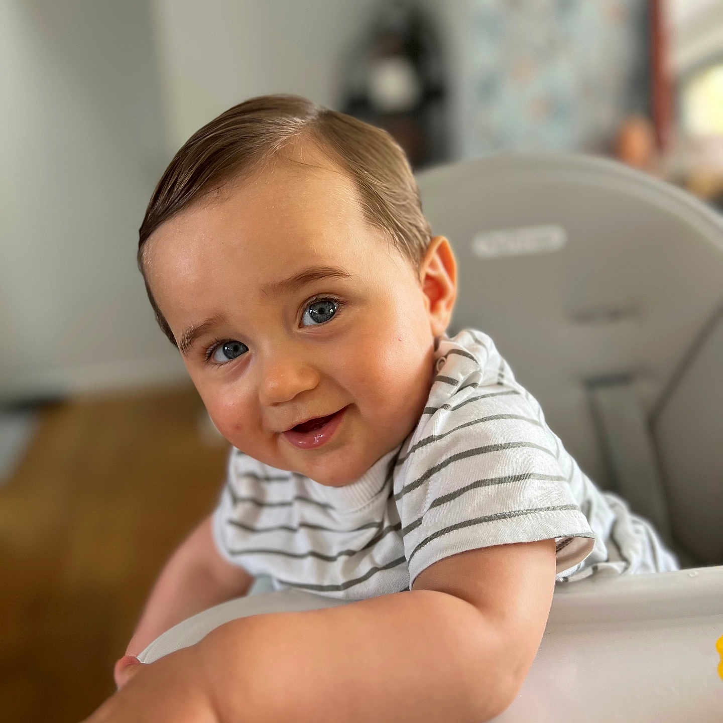 Nino a rejoint le concours — aidez-le/la à gagner de superbes lots ! arm, baby, blue_eyes, child, cute, face, furniture, hair, happy, high_chair, indoor, person, playful, portrait, skin, smile, striped_shirt, table, toddler, young