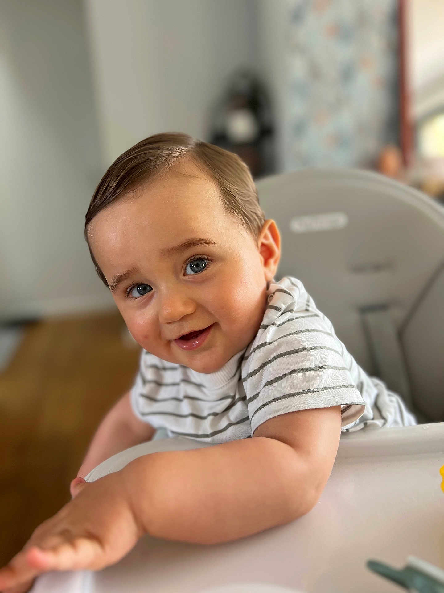 Nino a rejoint le concours — aidez-le/la à gagner de superbes lots ! toddler, child, smile, high_chair, striped_shirt, blue_eyes, indoor, cute, portrait, person, baby, happy, skin, hair, arm, face, furniture, table, playful, young