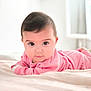 baby, infant, child, pink_clothing, bed, blanket, face, eyes, hair, indoor, light, soft_texture, portrait, cute, young, lying_down, curious, person, cozy, room
