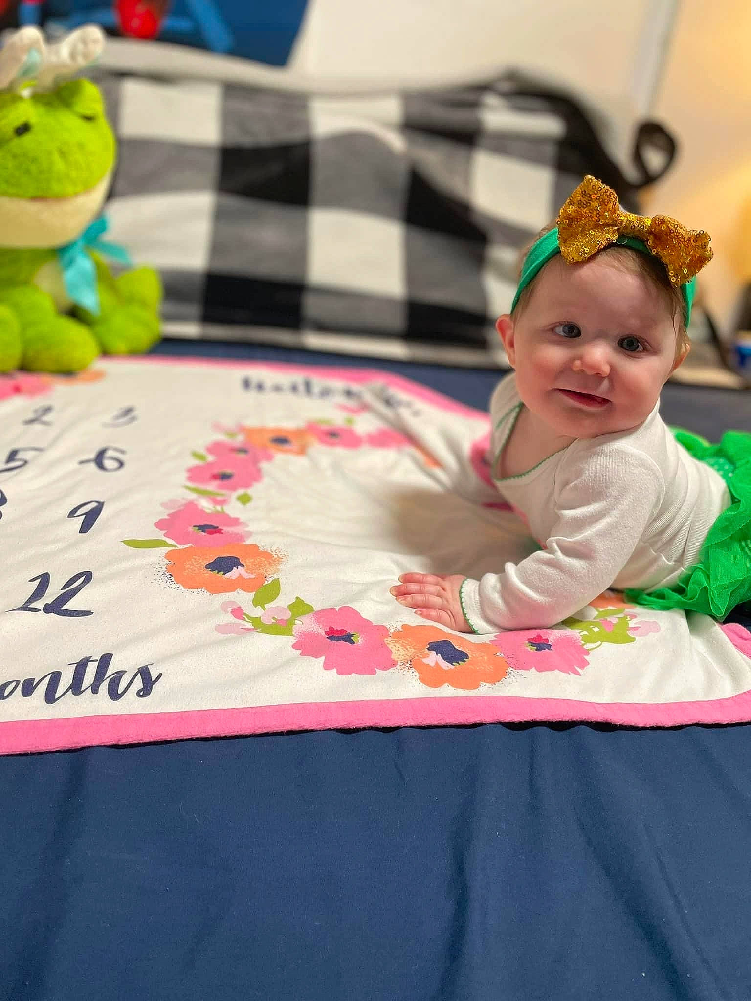 Riley is registered to the contest to win money with this photo: baby, baby_toddler_clothing, child, design, event, fun, green, happy, headpiece, jewellery, leisure, linens, magenta, pattern, person, play, recreation, room, textile, toddler