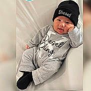 Diesel joined the competition — help win amazing prizes! baby, infant, child, grey_clothing, beanie, hat, Diesel_brand, smiling, cute, portrait, sitting, relaxed, indoor, person, face, headwear, cozy, fashion, monochrome, soft_background