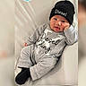 baby, infant, child, grey_clothing, beanie, hat, Diesel_brand, smiling, cute, portrait, sitting, relaxed, indoor, person, face, headwear, cozy, fashion, monochrome, soft_background