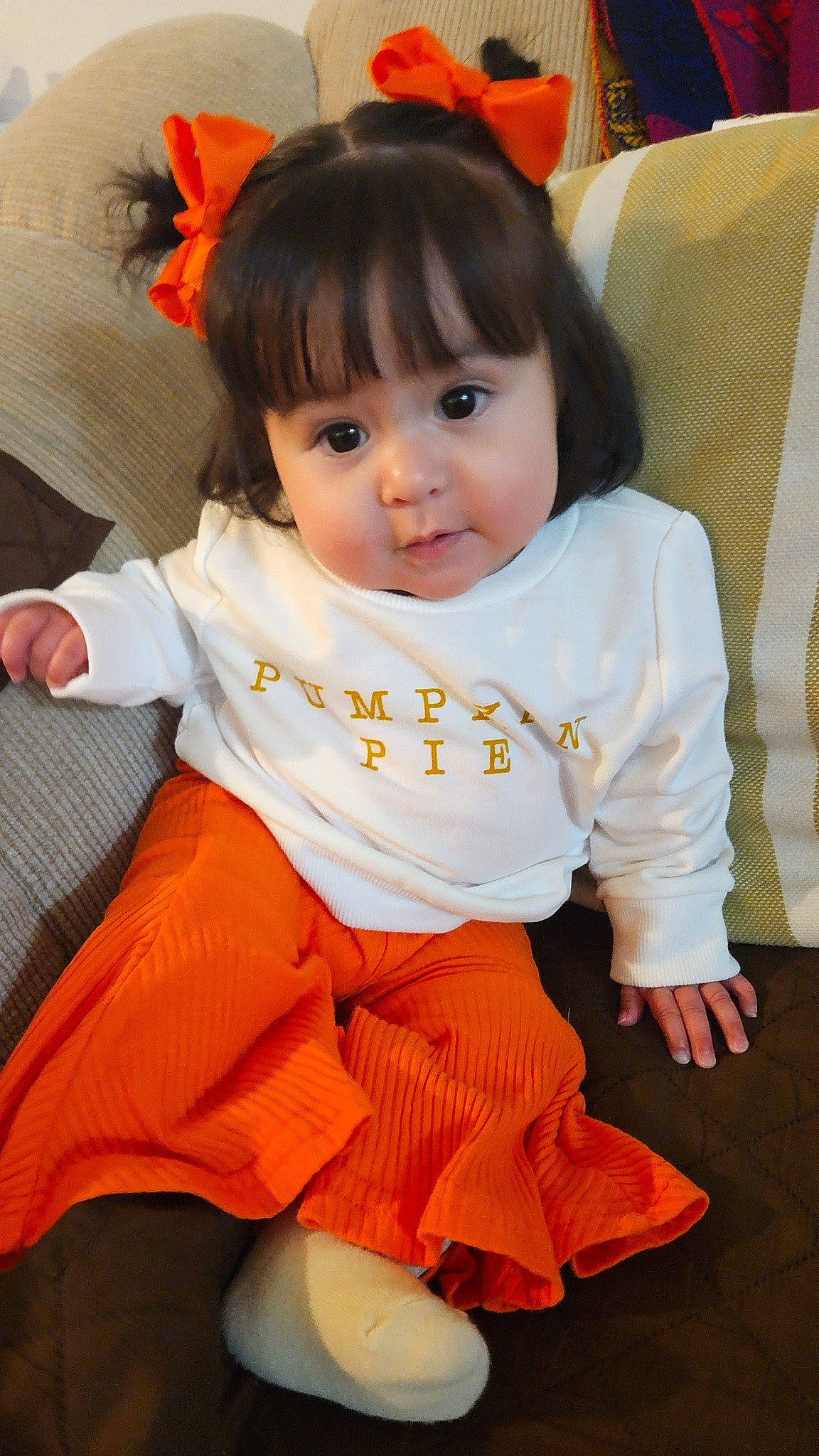 Callie Tolayo joined the competition — help win amazing prizes! baby, baby_toddler_clothing, bangs, cheek, child, comfort, couch, flooring, fun, hairstyle, happy, head, human_body, orange, peach, person, sitting, skin, sleeve, toddler