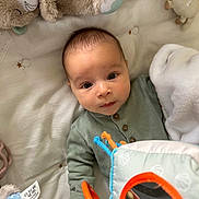 Jude a rejoint le concours — aidez-le/la à gagner de superbes lots ! baby, infant, child, toys, soft_toys, blanket, mirror, hand, green_clothing, buttoned_onesie, bed, cute, curious, indoors, portrait, face, looking_up, playtime, cozy, soft_lighting