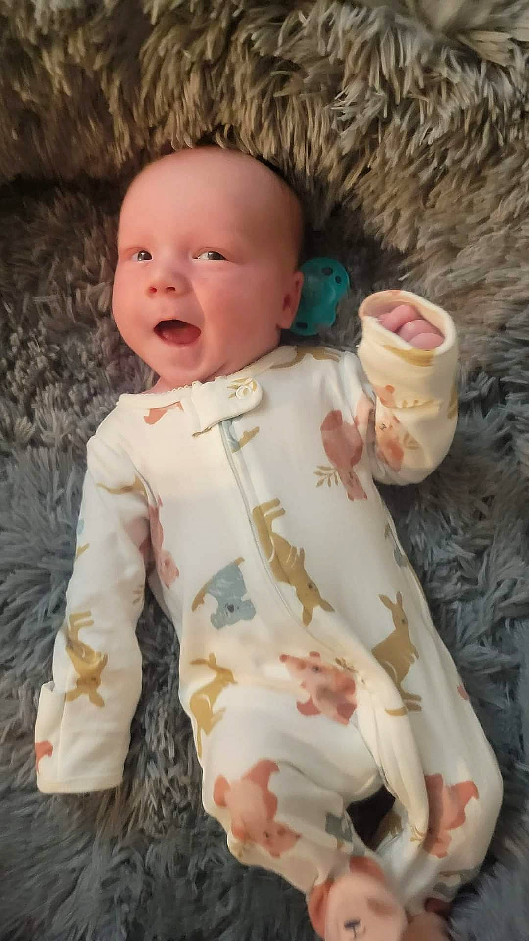 Dax is registered to the contest to win money with this photo: arm, baby, baby_toddler_clothing, cheek, child, doll, dress, happy, head, human_body, linens, lip, nose, pattern, person, sitting, skin, sleeve, smile, toddler