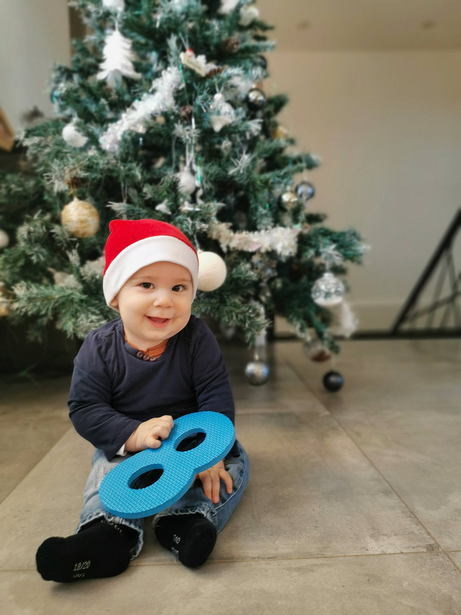 Aaron participe au concours pour gagner de l'argent avec cette photo : baby_toddler_clothing, christmas_decoration, christmas_ornament, christmas_tree, event, facial_expression, fun, happy, headwear, holiday, holiday_ornament, joy, ornament, person, smile, standing, tire, toddler, tree, vehicle