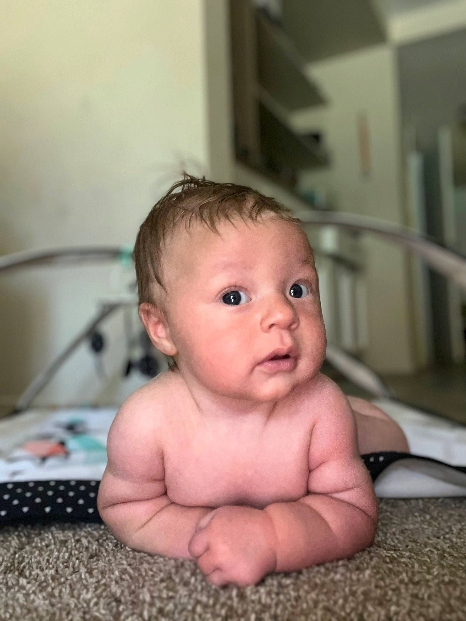 Fletcher is registered to the contest to win money with this photo: baby, bathing, cheek, chest, chin, eye, eyebrow, eyelash, finger, flooring, happy, head, iris, lip, mouth, nose, person, sitting, skin, thumb