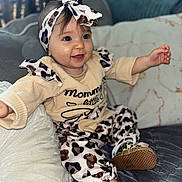 Kyara a rejoint le concours — aidez-le/la à gagner de superbes lots ! baby, infant, child, smiling, happy, leopard_print, headband, outfit, sitting, couch, pillow, indoors, cute, small_shoes, clothing, person, portrait, young_child, soft_lighting, cozy