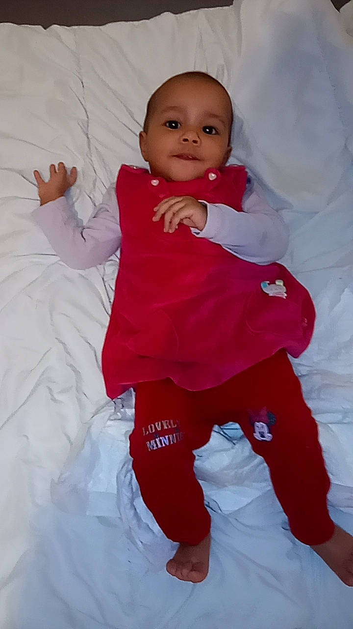 Eve a rejoint le concours — aidez-le/la à gagner de superbes lots ! baby, baby_toddler_clothing, carmine, cheek, child, fun, gesture, happy, linens, magenta, pattern, peach, people_in_nature, person, pink, play, sleeve, smile, t_shirt, thumb