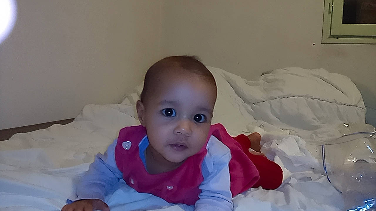 Eve a rejoint le concours — aidez-le/la à gagner de superbes lots ! baby, baby_toddler_clothing, cheek, child, comfort, eye, flash_photography, happy, iris, linens, lip, mouth, nose, person, picture_frame, room, sitting, skin, sleeve, smile