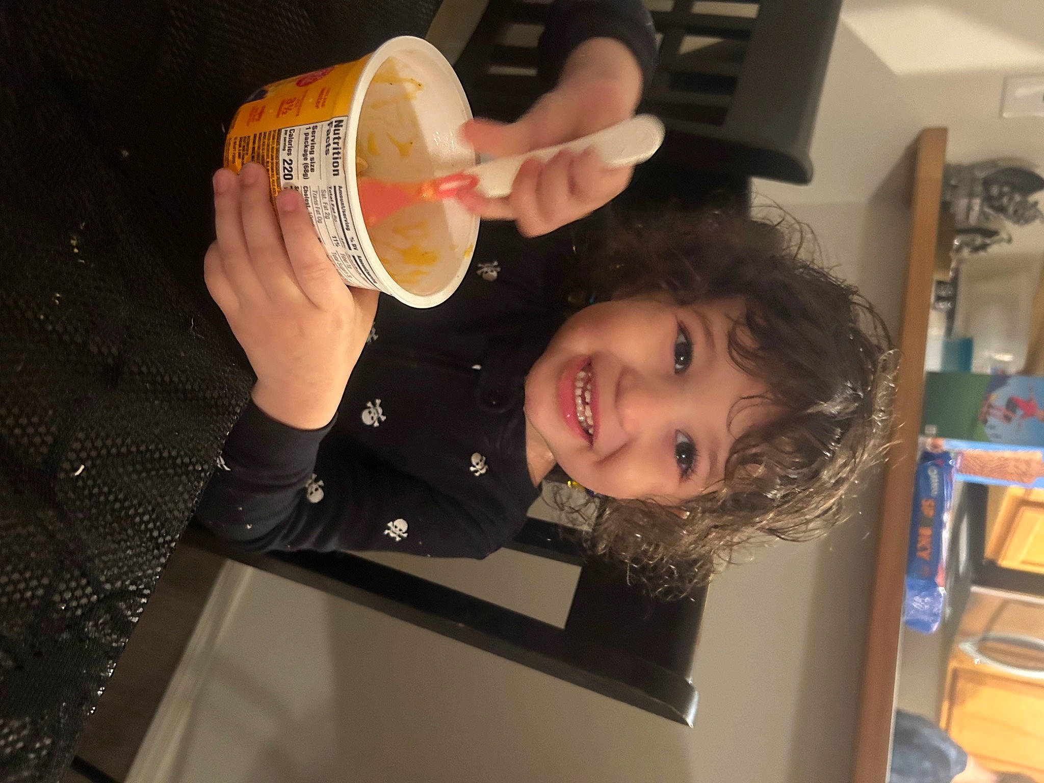 Ella is registered to the contest to win money with this photo: child, comfort_food, drink, drinking, drinkware, finger, food, fun, gesture, happy, joy, junk_food, nail, person, plate, room, shelf, smile, tableware, thumb