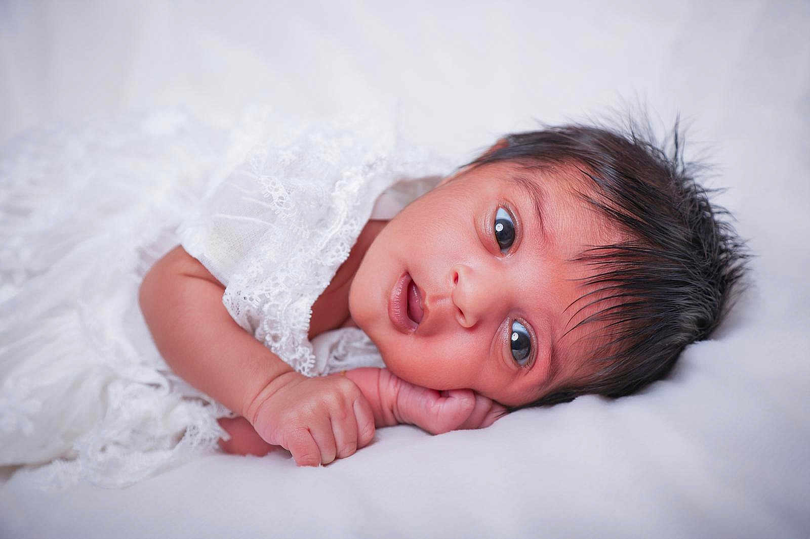 Ishwali a rejoint le concours — aidez-le/la à gagner de superbes lots ! baby, newborn, infant, face, eyes, hand, lace, blanket, white_background, soft, cute, portrait, lying_down, skin, head, hair, resting, closeup, sleepy, peaceful