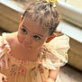 Sofia a rejoint le concours — aidez-le/la à gagner de superbes lots ! toddler, child, girl, yellow_bow, hair_tie, floral_dress, curly_hair, indoors, window_light, soft_focus, cute, curious, portrait, baby, person, young_child, fashion, closeup, natural_light, dressed_up