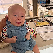 Wes joined the competition — help win amazing prizes! baby, smiling, child, kitchen, denim_overalls, striped_shirt, socks, toy, counter, papers, refrigerator, stove, hand, window_blinds, happy, indoor, person, face, infant, home